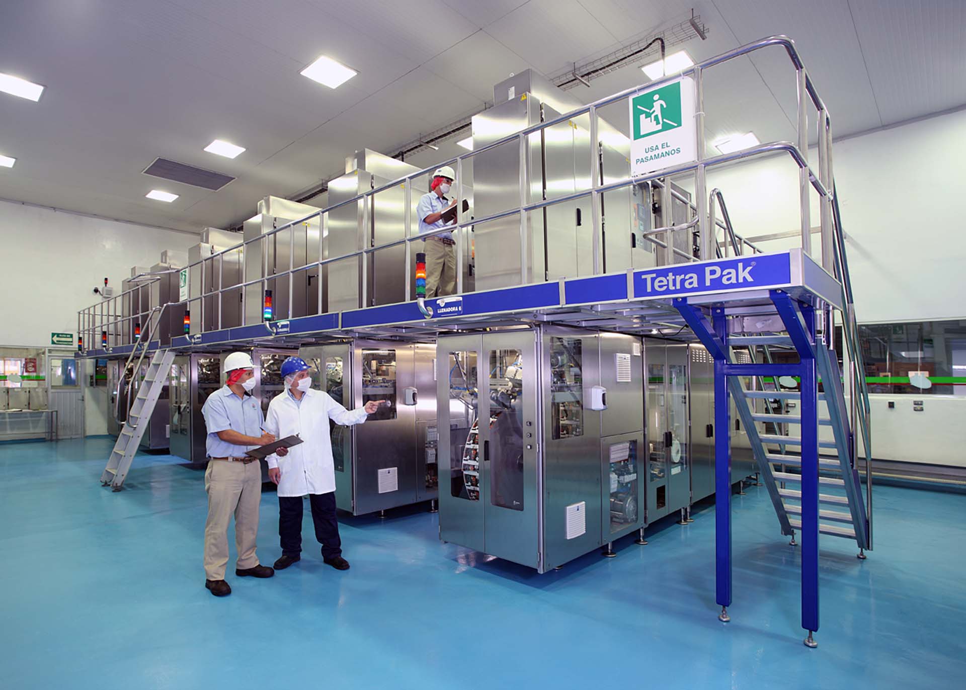 Workers monitoring production at a Tetra Pak packaging facility.